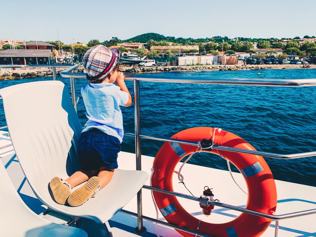 ⭐️Nominated ⭐️ Little boy looking at the sea from yacht staying on his knees on white chair close to