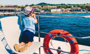 ⭐️Nominated ⭐️ Little boy looking at the sea from yacht staying on his knees on white chair close to